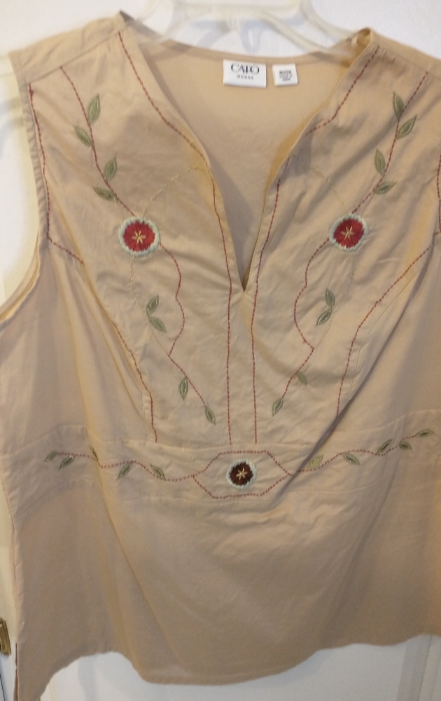 Sleeveless top with soft red flower embroidery.